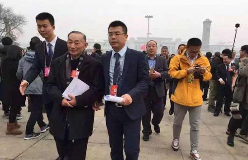 工作人员掺扶开完全体会议的梅葆玖先生上车返回住地