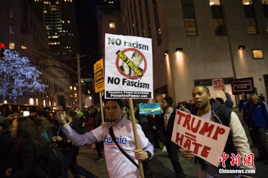 当地时间4月14日晚，民众在纽约洛克菲勒广场附近进行反特朗普游行。 <a target='_blank' href='http://www.chinanews.com/'>中新社</a>记者 廖攀 摄