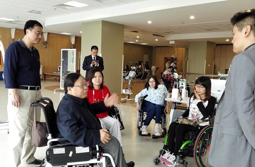　图为吕世明一行看望接受康复体验的残疾人患者