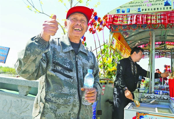 4月9日，一位老人在努尔买买提的摊位上领到免费矿泉水。