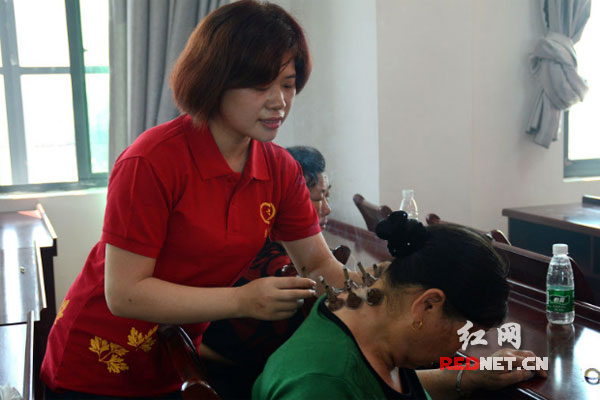 爱心团队的护师和志愿者为老年人进行艾灸理疗。