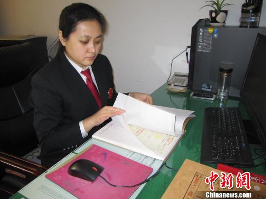 图为刘彦在翻阅案卷。　李忠勇 摄