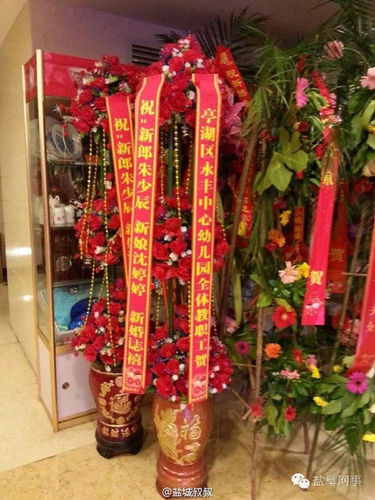 酒店门口摆有不少宾客送来的祝?；ɡ?，其中一个花篮署名为“亭湖区永丰中心幼儿园全体教职工贺”。