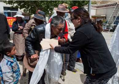 自治区福彩中心主任唐慧向曲水江曲疗养院老人敬献哈达，并送上1000元慰问金和慰问品