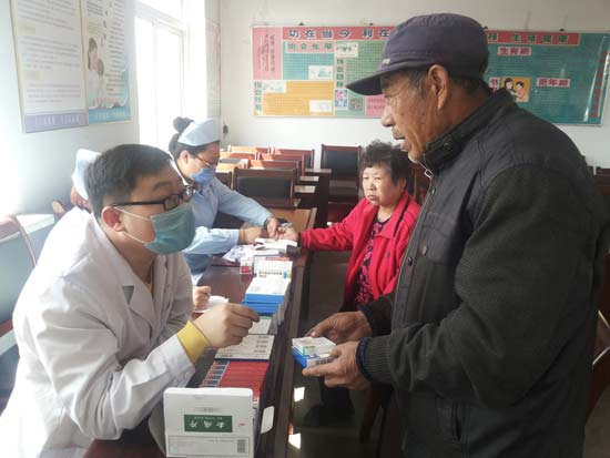 图为医疗保健院义工队为西大窑村民义诊送药