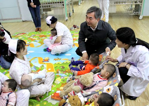图为省委常委、宣传部长梁伟年看望孤残儿童