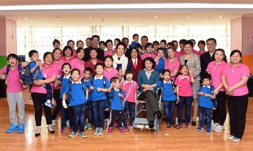 　图为彭丽媛看望慰问孤残儿童并合影留念
