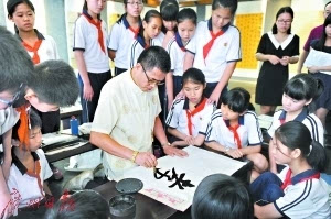 　同学们观看书法家示范“孝感动天”的写法。莫伟浓 摄