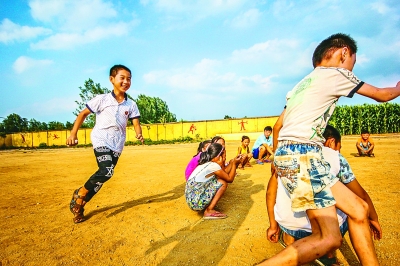 一群留守在大山里的孩子在操场上玩耍。