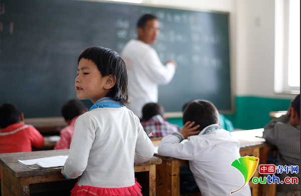 　6岁的藏族女孩黄娜姆措站着听黄老师讲课。黄三英的课堂上氛围很活跃，孩子们跟黄老师一起，又学习、又玩耍。中国青年网记者 张炎良 摄