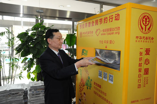 中华慈善总会会长李本公向“爱心屋”投递废旧报纸