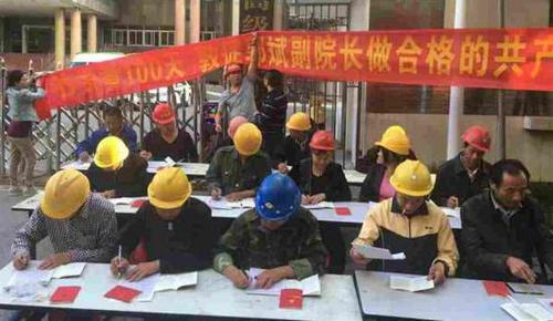 2016年5月23日，一群头戴安全帽，打扮为民工模样的人在江西高院门前，坐成三排抄写党章。