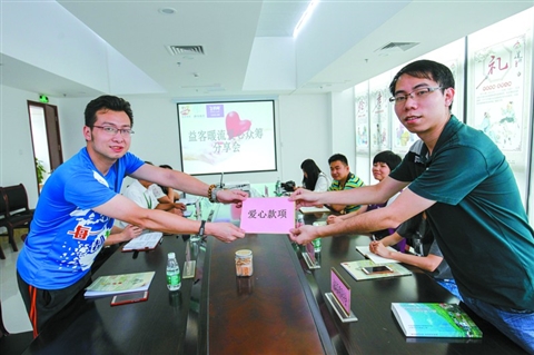 　　5月25日，益客暖流爱心众筹分享会在高明好人工作室开启。爱心商家代表(右)向公益联盟单位代表献上爱心款项。