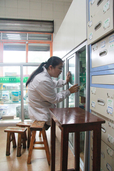 李菊洪跃到长条凳上给患者取药