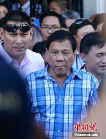 12月8日，菲律宾南部重镇达沃市市长杜特尔特前往位于马尼拉的菲律宾选举委员会正式提交参选总统的报名表，数千名支持者被动员到场力挺。图为杜特尔特（中）离开选举委员会。 70岁的杜特尔特长期在达沃市掌权，他原本报名参选达沃市长，但11月27日撤销竞选市长的报名表，替换同党人士报名角逐总统。最新民调显示，杜特尔特民意支持率后来居上，在众多总统参选人中位列第一，显现“黑马”姿态。2016年5月，菲律宾举行总统大选，政坛各个阵营正摩拳擦掌，选战氛围日益炙热。中新社记者 张明 摄