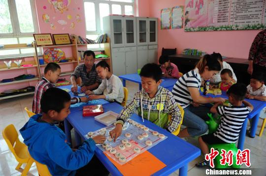 图为孩子们在“儿童之家”玩象棋?！∥滦焱?摄