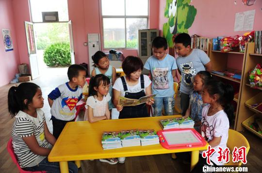 据了解，每个“留守儿童之家”专配一名儿童福利主任，负责教学设施管理和留守儿童的福利救助。图为儿童福利主任正在给孩子们传授知识。　温徐旺 摄