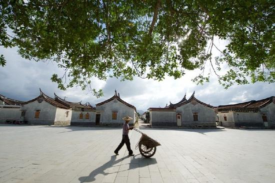 5月27日，一位村民推车经过埭美村口