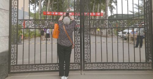 7日上午开考后，已经看不到孙子的李桂荣迟迟不愿离开，她想拍下考场内的照片，以作留念。本报记者魏新丽摄