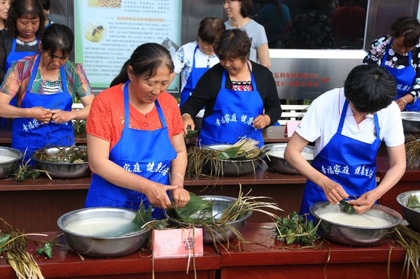 3、汤河源天河川滨水公园里各村选送的选手在进行包粽子速度比赛。