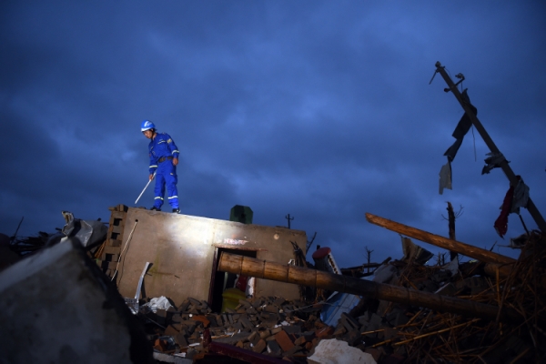 新华社照片，盐城（江苏），2016年6月24日
    黎明中的全面搜救
    6月24日黎明，搜救人员在盐城市阜宁经济开发区北陈村进行排查搜救。
    黎明时分，搜救人员继续在江苏省盐城市阜宁县受灾地区对厂房、民居等展开全面排查搜寻，营救受灾群众。23日下午，江苏省盐城市阜宁县、射阳县部分地区突发龙卷风冰雹严重灾害，多个乡镇受灾，造成大量民房、厂房、学校教室倒塌，部分道路交通受阻。据初步统计，已造成78人死亡，约500人受伤。
    新华社记者韩瑜庆摄