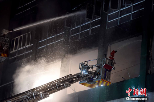 6月24日凌晨1时，香港九龙淘大工业村一迷你仓库火灾现场。本次火灾焚烧超过60小时仍未扑灭，已有两名消防员在火灾中殉职。 中新社记者 张宇 摄1