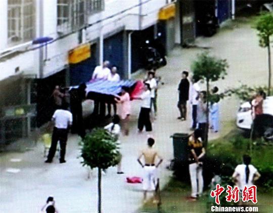 小区居民将棉被、床单等物抱出，准备接住男孩 宋俊初 摄