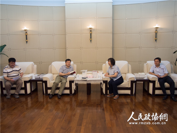 图为全国政协委员周秉建（右二）与人民政协报社党组书记、总编辑周北川（左二）进行座谈交流