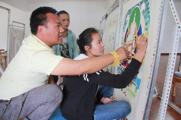 兰卡正在指导学生玛久吉给唐卡上色