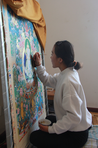 学生完德玛正在精心绘制唐卡
