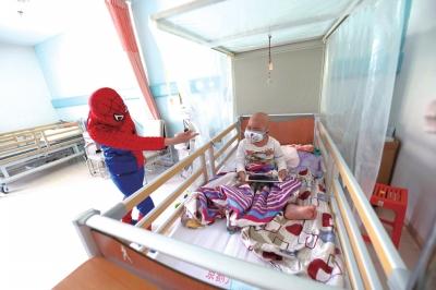 何燕梅扮演蜘蛛侠哄孩子开心。京华时报记者陶冉摄