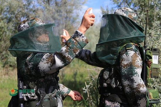 外出巡逻出发前，连队官兵互相为对方喷洒驱蚊液。