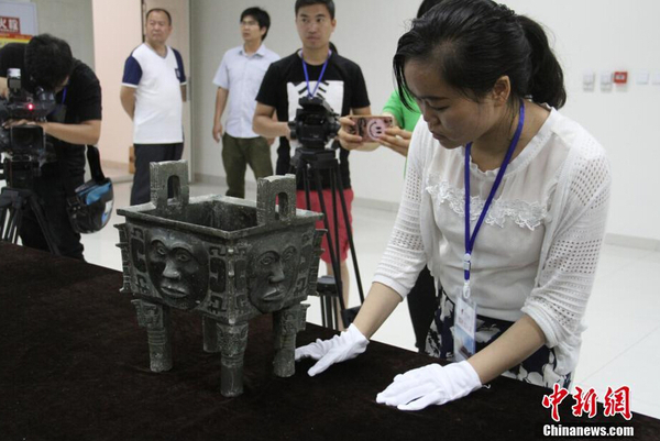 参展博物馆代表检查文物“大禾人面纹方鼎”。 中新社记者 钟欣 摄