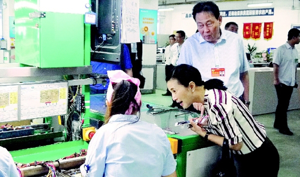 毛肯·赛衣提哈木扎委员与刘红宇委员在生产线上了解工人保障状况