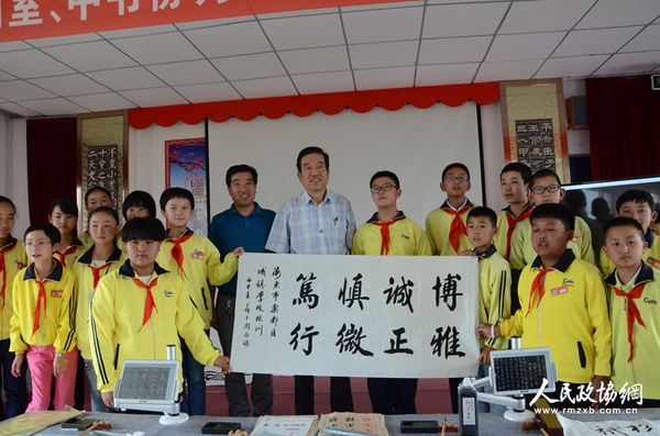 图片说明：政协委员与学生展示创作的书法作品。