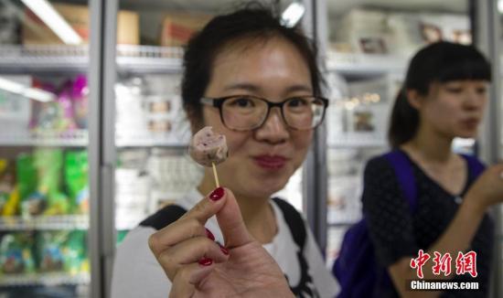 6月29日，北京国内首家供港生鲜门店内，首批试吃的顾客展示从广东阳江运来的鱼丸。供港生鲜是指从内地专门为港澳提供鲜活冷冻食品，至今已经历经54年历程，建立了一套规范的出口食品质量安全保障规范。近来在国家质检总局等部门支持下，供港生鲜企业和产品按照同线同标要求回归内地。7月1日，全国首家供港生鲜门店将在北京开店，一些从南海水域出产的食品来到北京“赶考”，首次接受内地消费者的考验。 <a target='_blank' href='http://www.chinanews.com/'>中新社</a>记者 张浩 摄