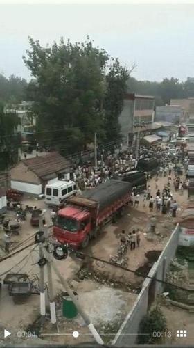 现场有一辆货车、两辆特警车以及一辆交通执法车，多名群众聚集在车辆旁边。 来源：视频截图