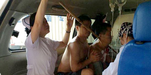 黄敏单膝跪地扶病人竹竿