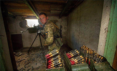 在掩体中作战的乌军机枪手，可见满装的弹药箱。