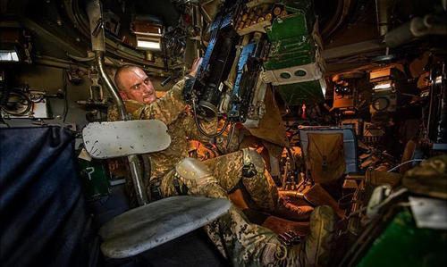 坦克兵在炮塔内调试武器。