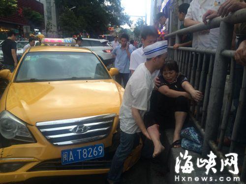 丈夫用身体顶住车子，一手托着妻子的伤腿 