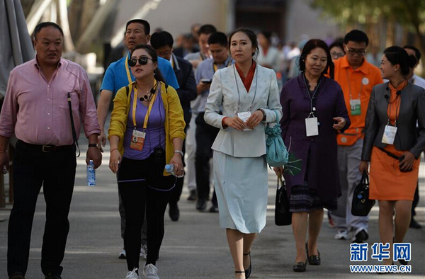 一名身着全新工作制服的莫高窟讲解员带领游客参观。 新华社记者 陈斌 摄 图片来源：新华网