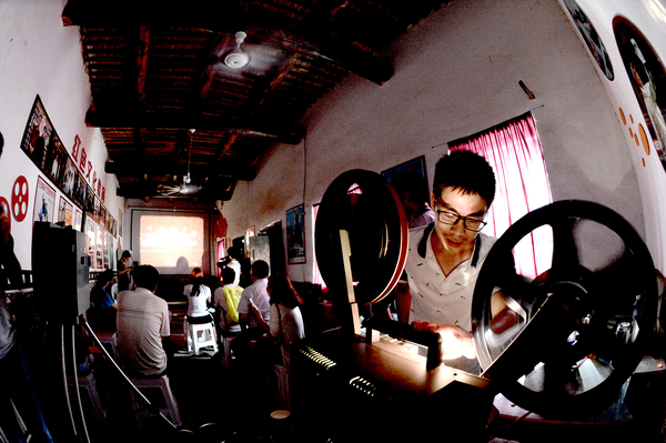 0028四留固是南吕固乡的一个村，这个村的出名，完全是因为村里出了个电影收藏家魏少先，很多人都跑来参观他的电影博物馆。图为老魏的小儿子在播放红色影片