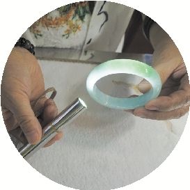 经营一家文玩宝石店的店主黄海燕展示品质较好的翡翠手镯。