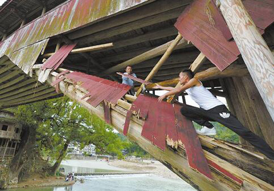 在几座被冲毁的廊桥旁，堆满了被追寻回来的廊桥结构件。杨冰杰 摄