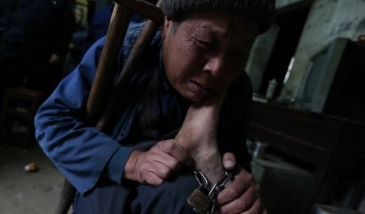 家人给老人脚上栓铁链2