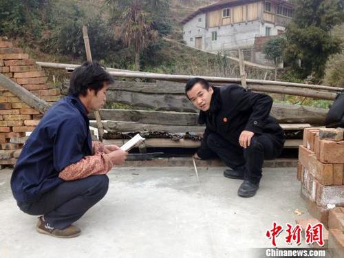 资料图：黄智(右一)到当事人所在地进行实地测量、办案。　贾冬苗 摄