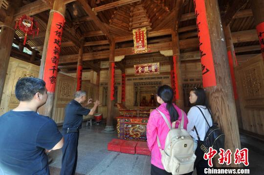 　　图为70余岁的退休教师林乐妙（左二）担任起普照堂的“讲解员”，每天义务为外地来的游客追古溯今?！≌疟蟆∩? longdesc=