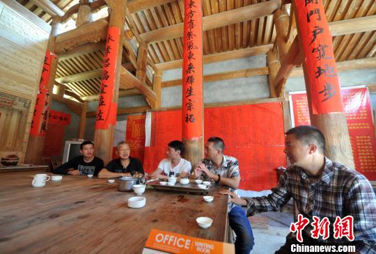 图为阳春村村民们聚在一起聊章公祖师跨国追讨有关进展。　张斌 摄