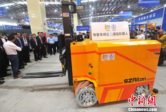 图为与会领导嘉宾参观智能车间全向搬运机器人?！≌疟?摄